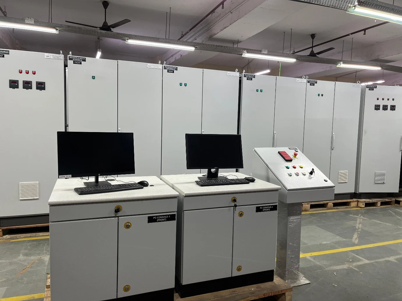 Industrial control desks and operator console in front of panel cabinets